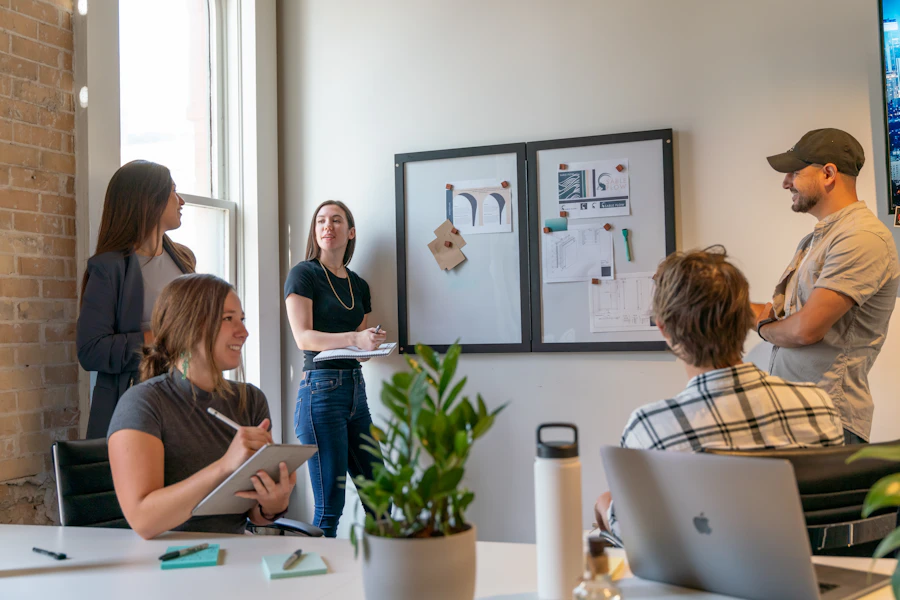 A product team talking through app designs pinned on the wall